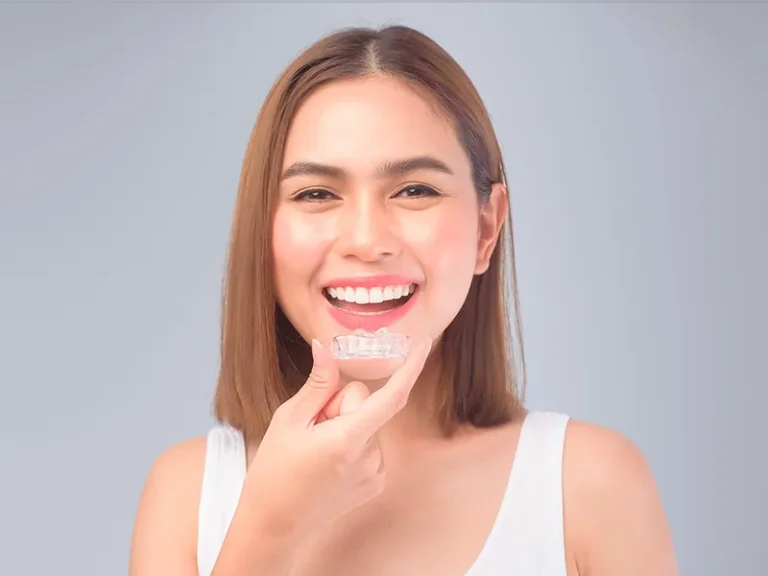 Invisalign 9 Smiling woman holding clear aligner as part of Bellingham dental care services.