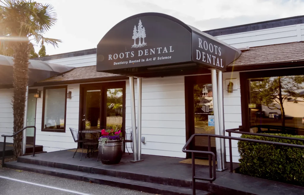 Why Choose Us 6 Your Dentist in Bellingham, WA | Roots Dental - Front entrance of Roots Dental clinic in Bellingham with signage, seating, and welcoming flowers.