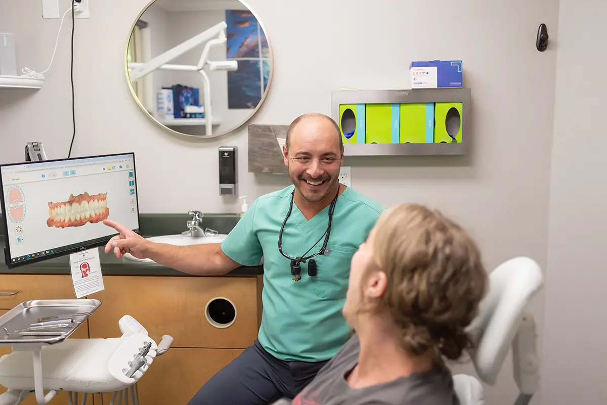 Office Tour 2 Dr. Joshua Clarkman of Roots Dental in Bellingham showing a patient a 3D digital model of teeth during a dental consultation.