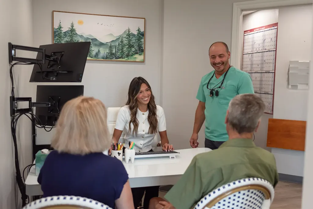 Testimonials 24 Dr. Joshua Clarkman and a team member at Roots Dental in Bellingham, WA smiling during a friendly dental consultation with patients.