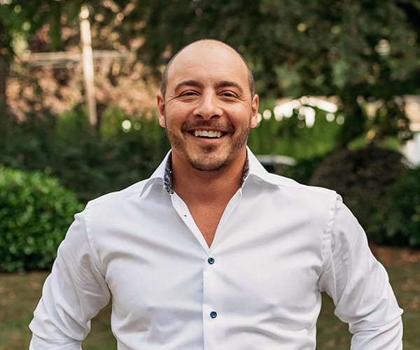 Invisalign 11 Dr. Joshua Clarkman, dentist at Roots Dental in Bellingham, smiling in a professional outdoor portrait.