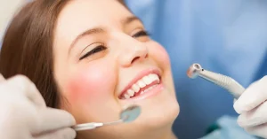 Smiling woman receiving a routine dental exam, representing non-urgent dental care and preventive dentistry.